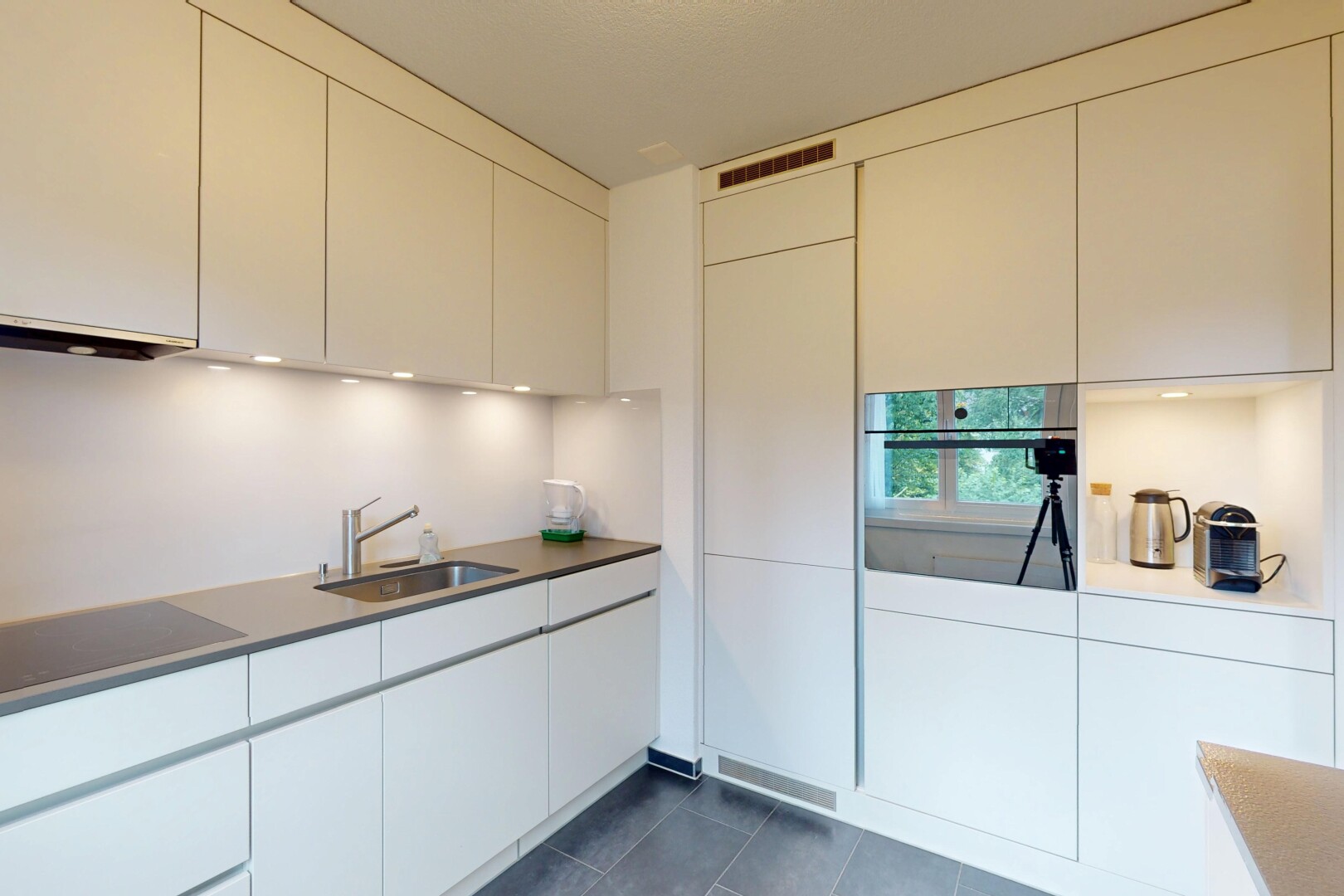 kitchen featuring stainless steel oven, dark tile patterned floors, black electric stovetop, and modern cabinets