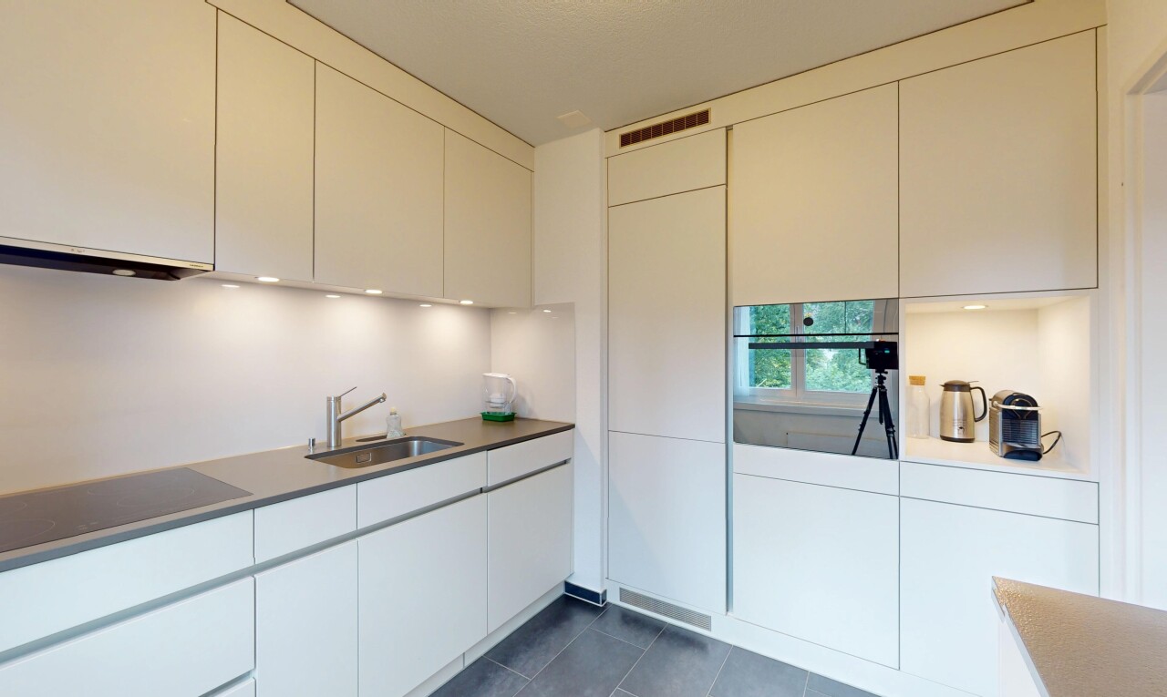 kitchen featuring stainless steel oven, dark tile patterned floors, black electric stovetop, and modern cabinets
