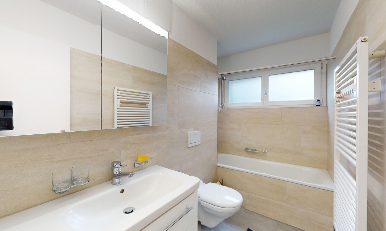 bathroom with radiator, a towel warming rack, vanity, and tile walls