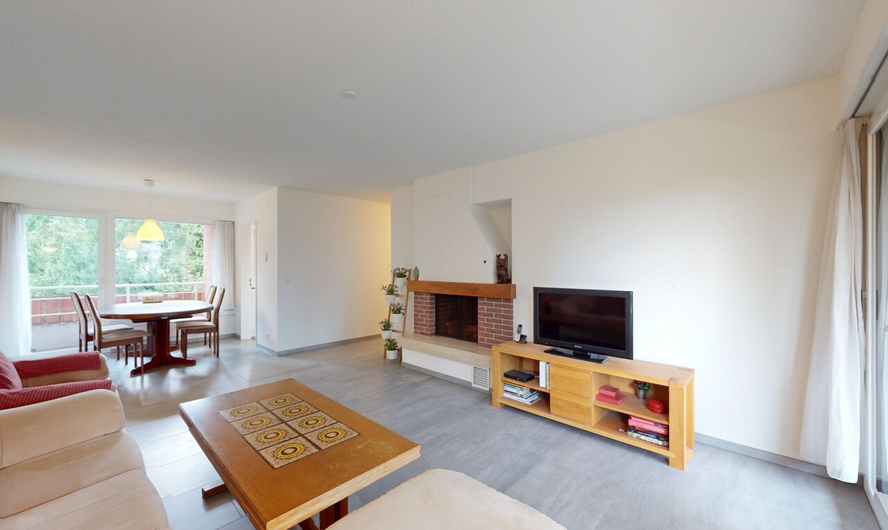 living / dining area featuring a brick fireplace and wood finished floors