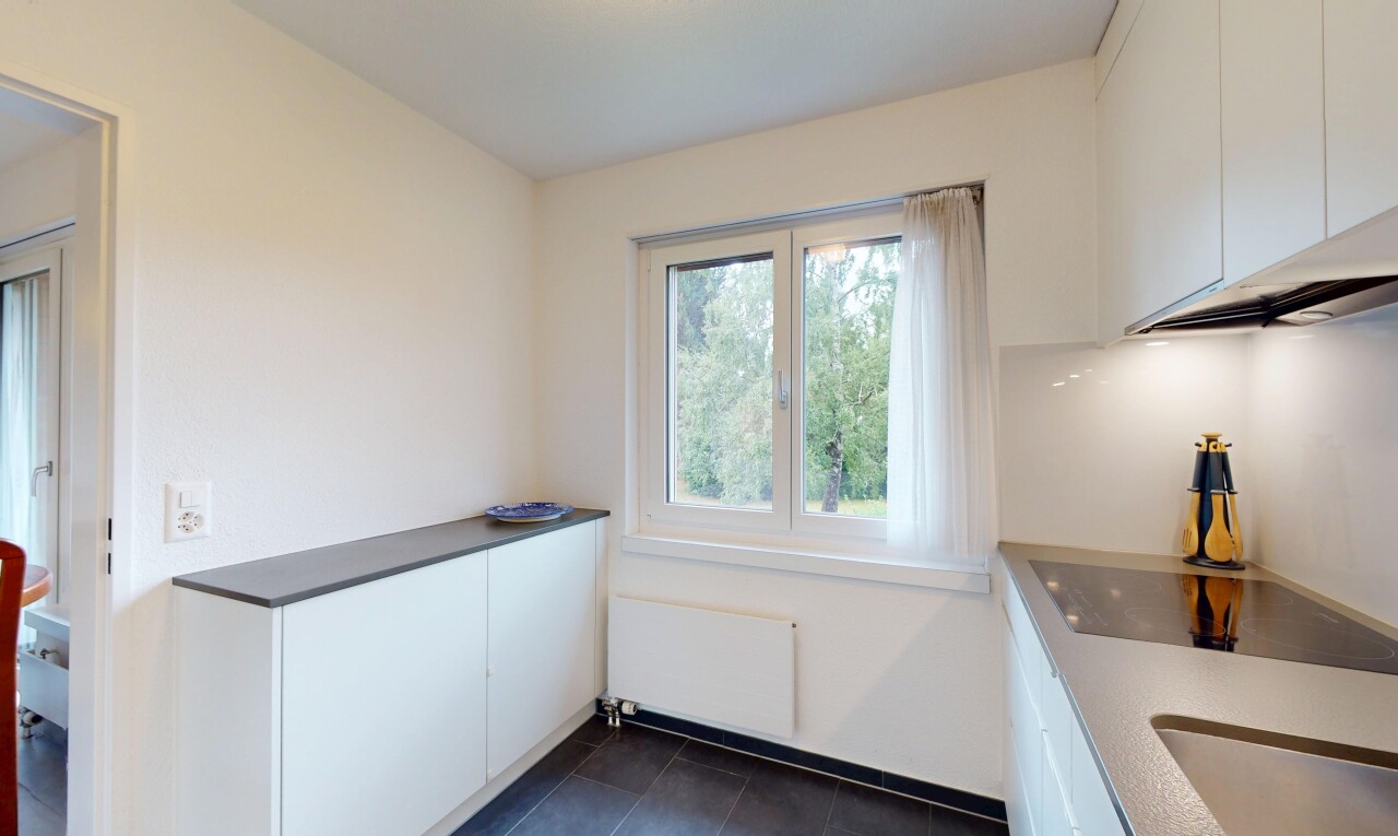 kitchen featuring radiator, white cabinets, black electric stovetop, and dark tile patterned floors