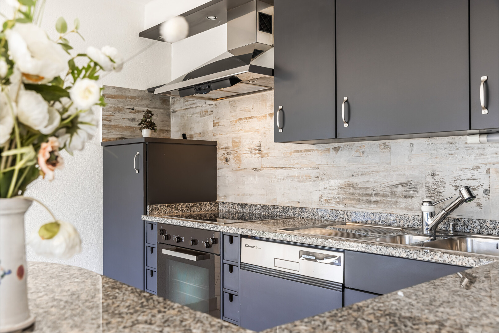 cuisine avec hotte, four, inside property, stone countertops, et plans de travail en pierre