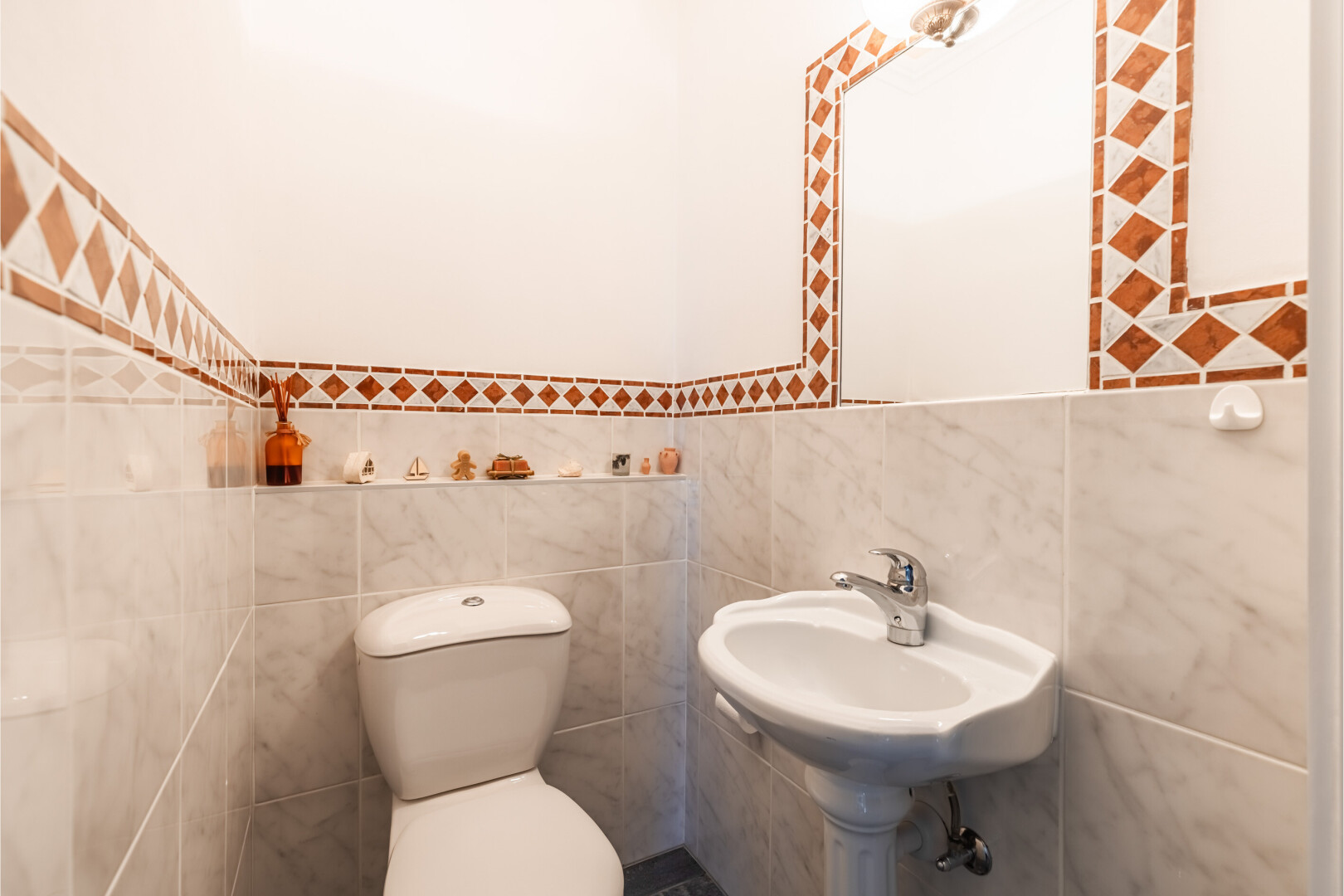 salle de bains avec toilette, miroir, inside property, tile wall, et mur en carrelage