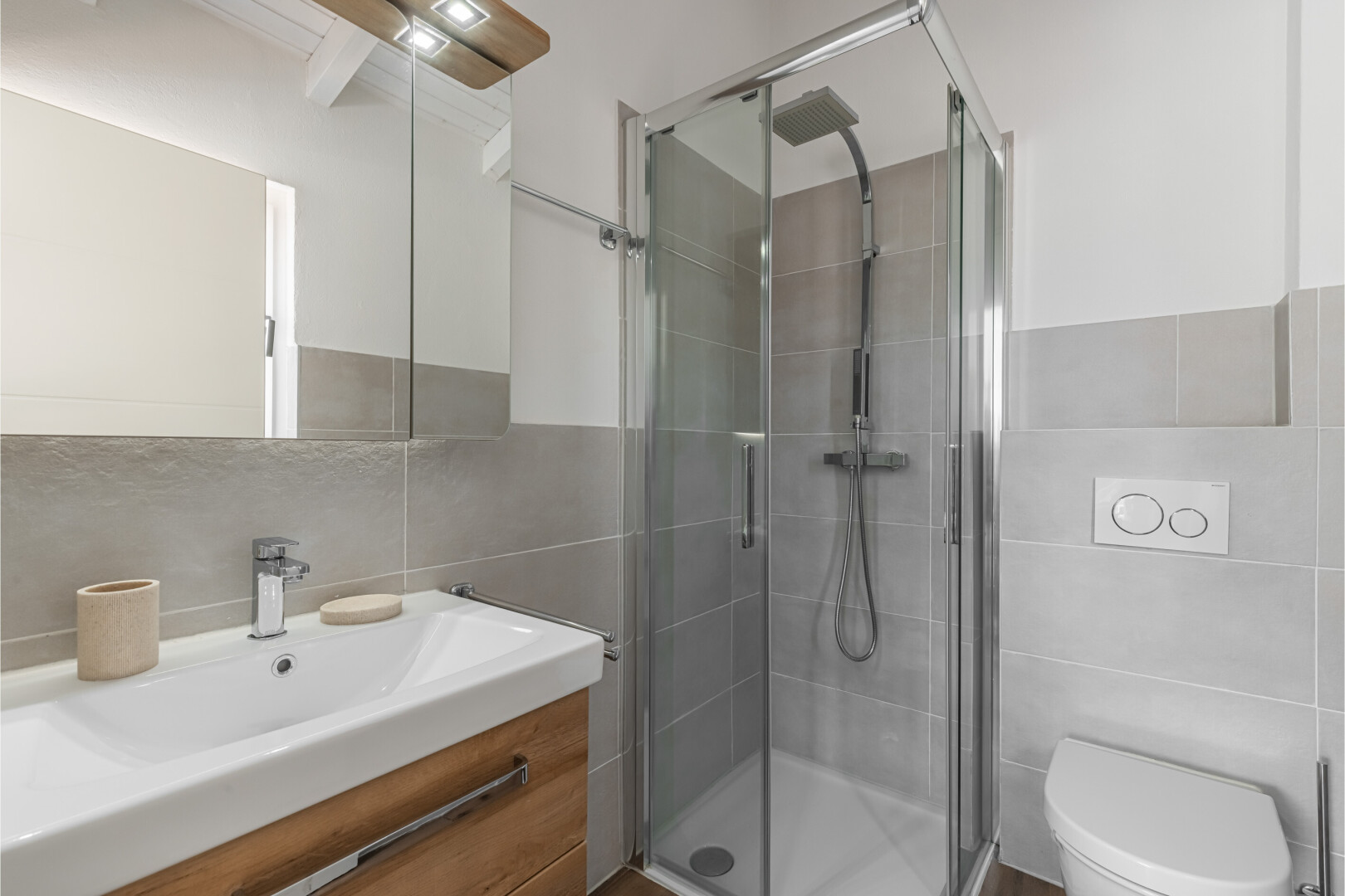 salle de bains avec mur en carrelage, tile wall, lavabo (ou coiffeuse selon le contexte), miroir, et salle de bain complète