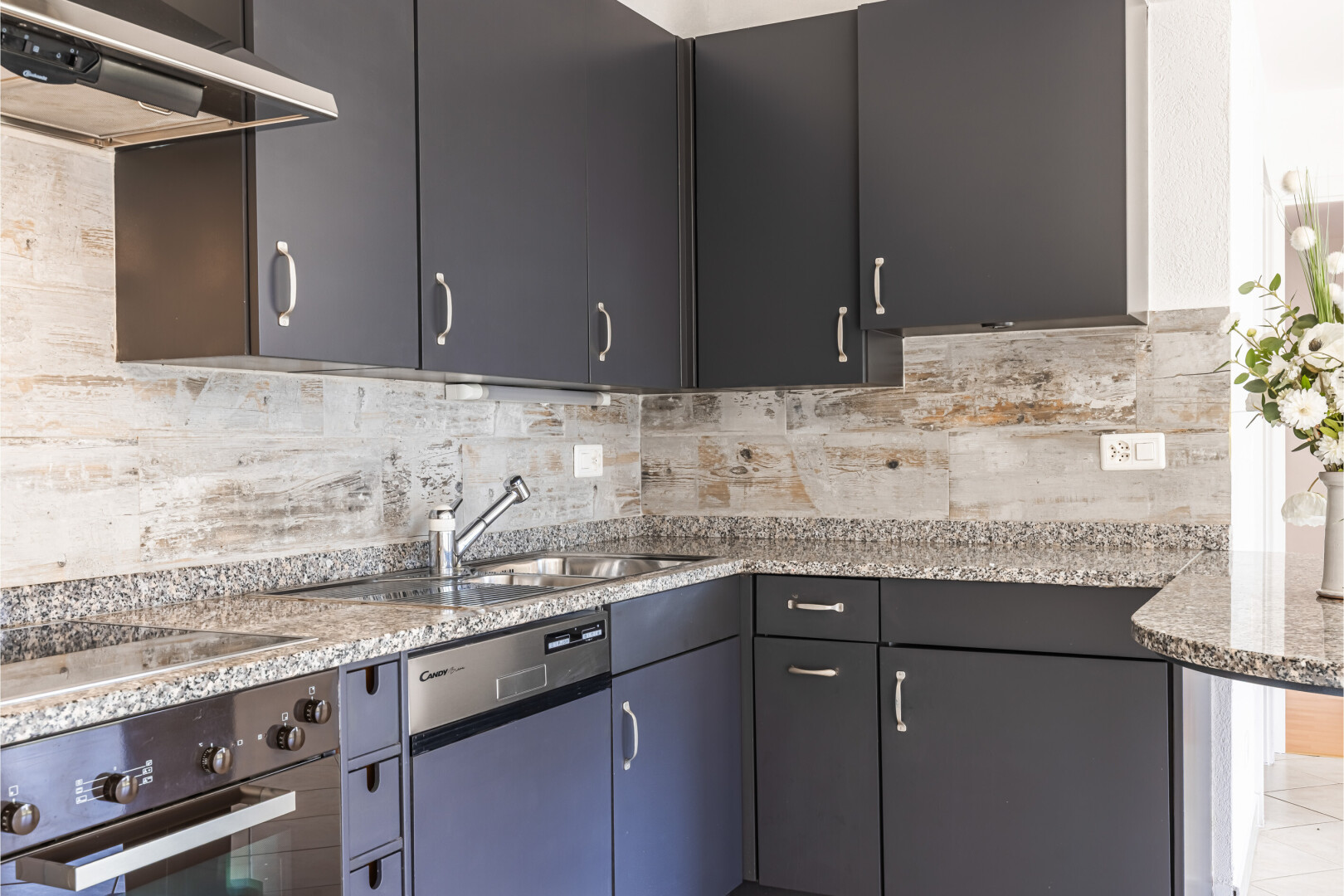 cuisine avec hotte, four, inside property, stone countertops, et plans de travail en pierre
