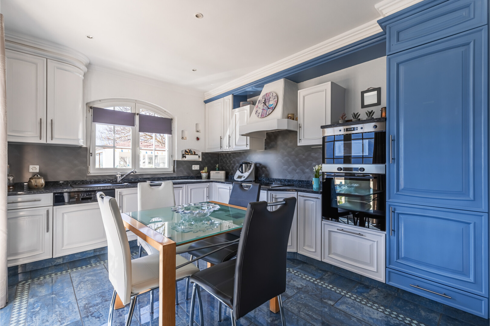 cuisine avec inside property, dark floor, dark countertops, plans de travail, et white cabinets