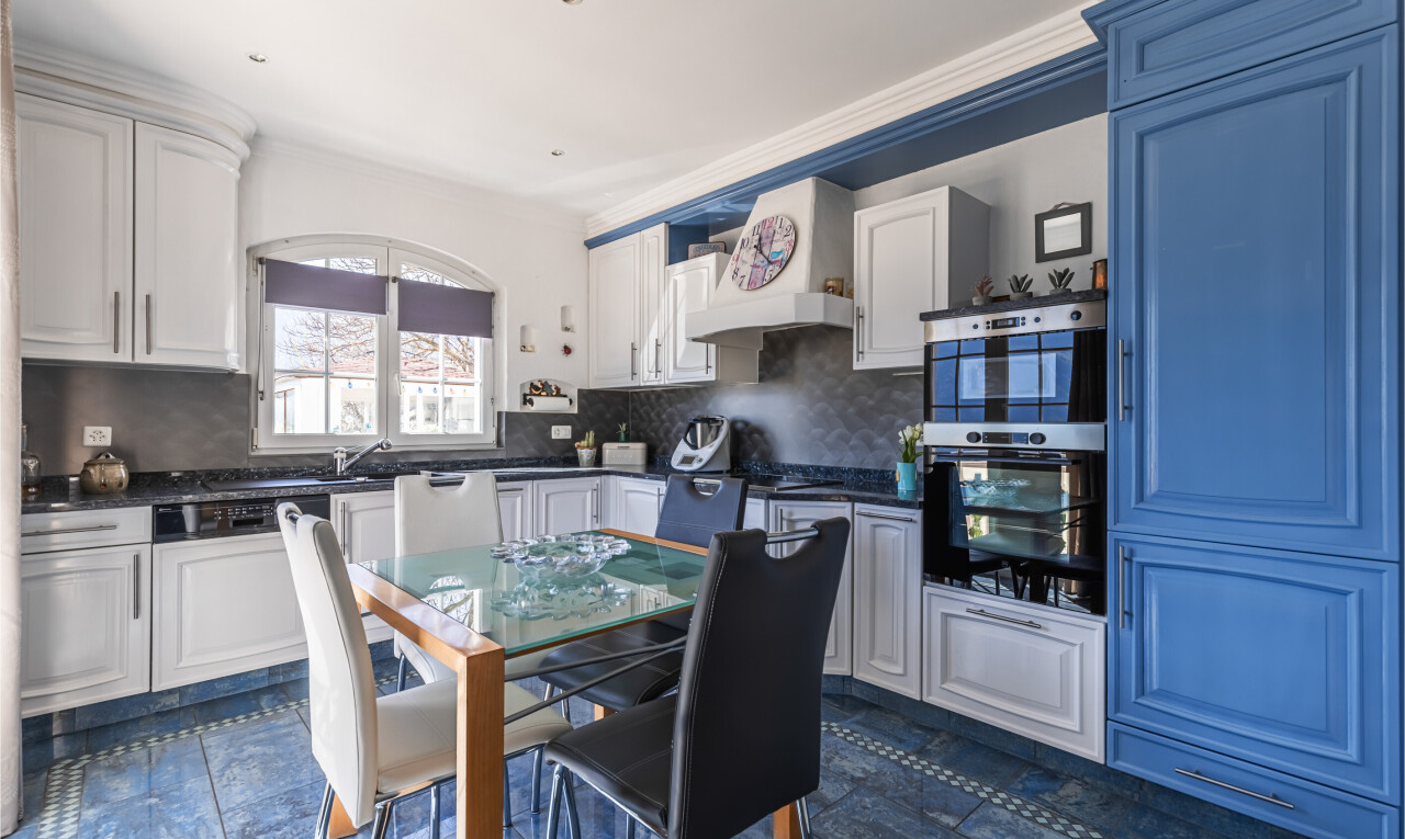 cuisine avec inside property, dark floor, dark countertops, plans de travail, et white cabinets