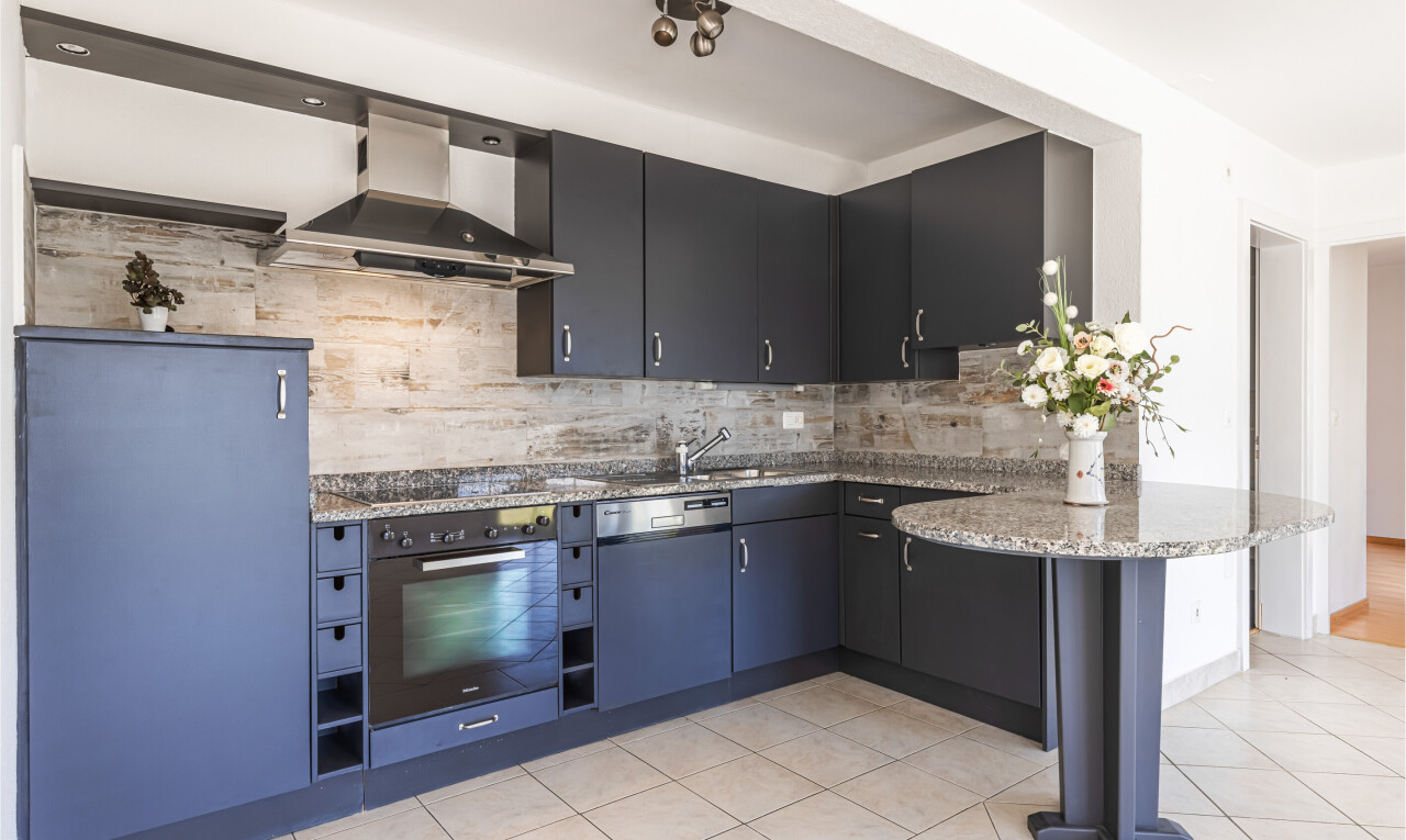 küche mit curved countertops, dunstabzugshaube, ofen, light floor, und küchenrückwand beim Herd