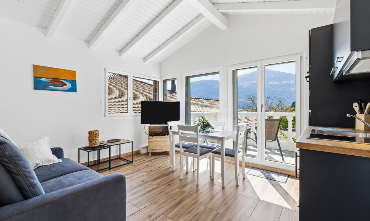 salon / salle à manger avec cloison sèche, drywall, lumière naturelle, natural light, et sol en finition bois
