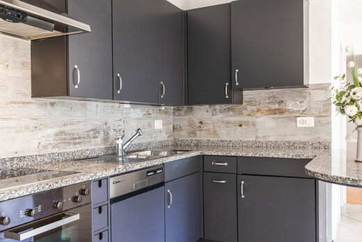 cuisine avec hotte, four, inside property, stone countertops, et plans de travail en pierre