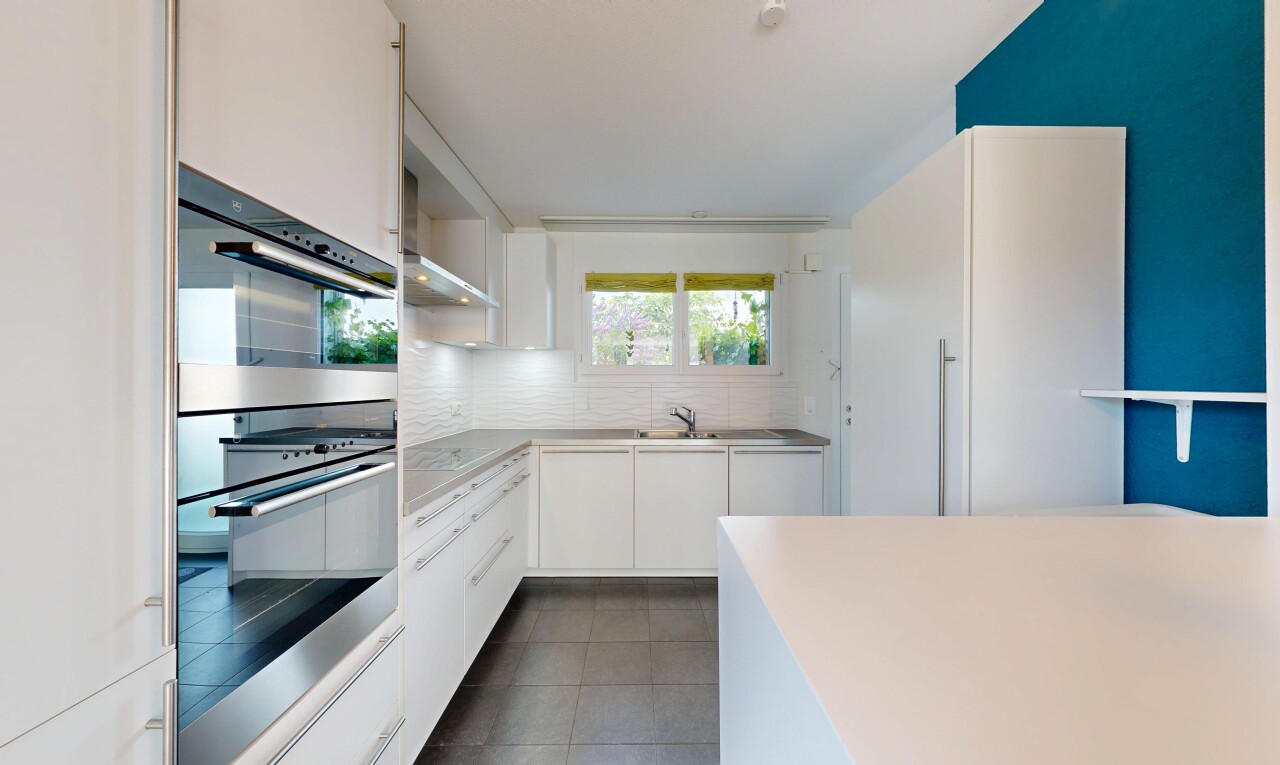 cuisine avec four double, armoires blanches, white cabinets, light countertops, et sol en carrelage