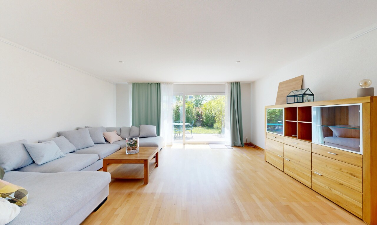 salon avec wood finish floor, sol en finition bois, drywall, cloison sèche, et inside property