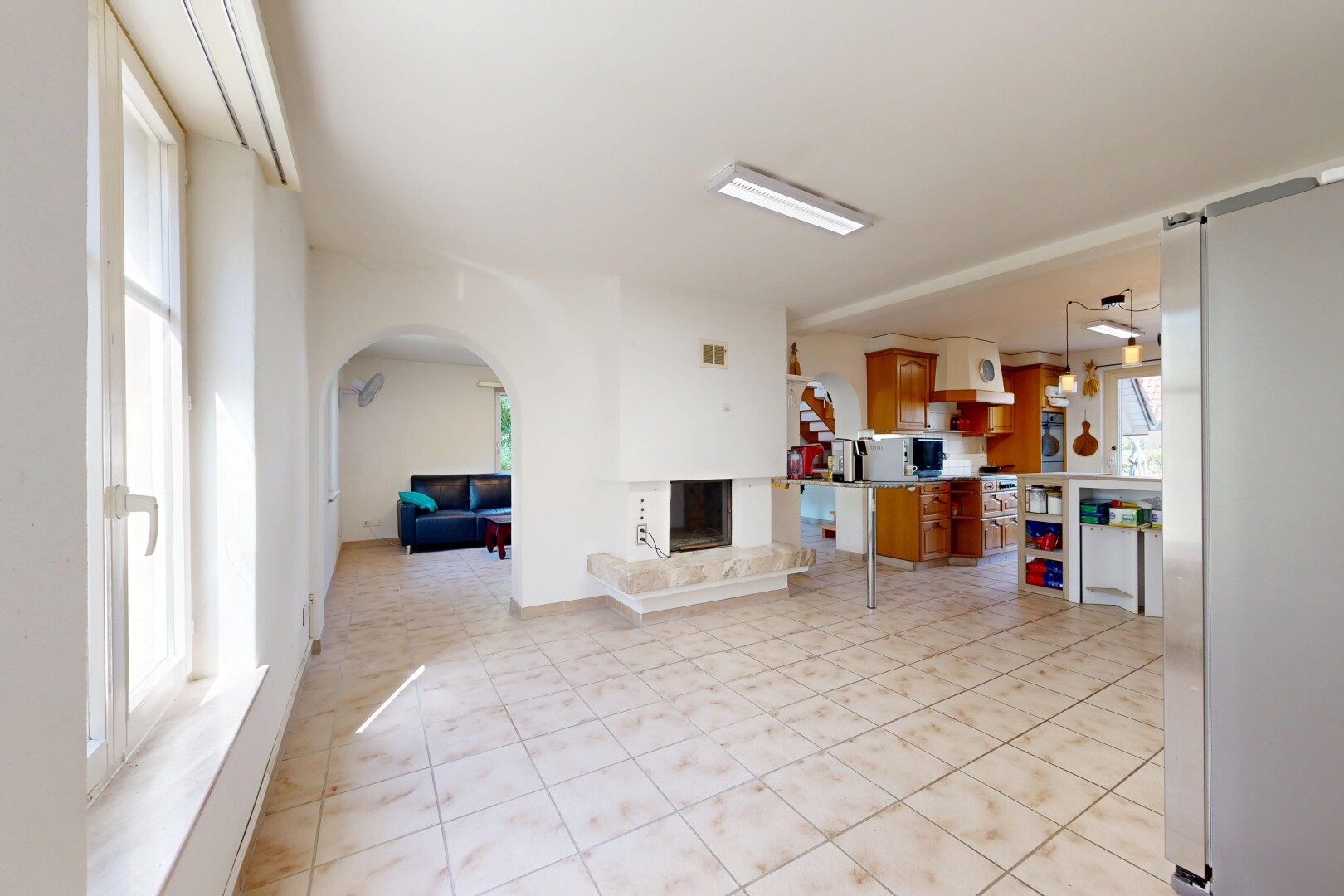 wohnzimmer mit gewölbte gehwege, kamin, drywall, gipskartonwand, und light floor