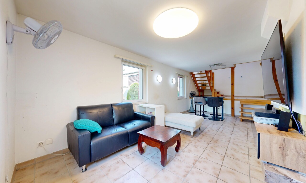 wohnzimmer mit treppen, fernseher, gipskartonwand, drywall, und natürliches licht