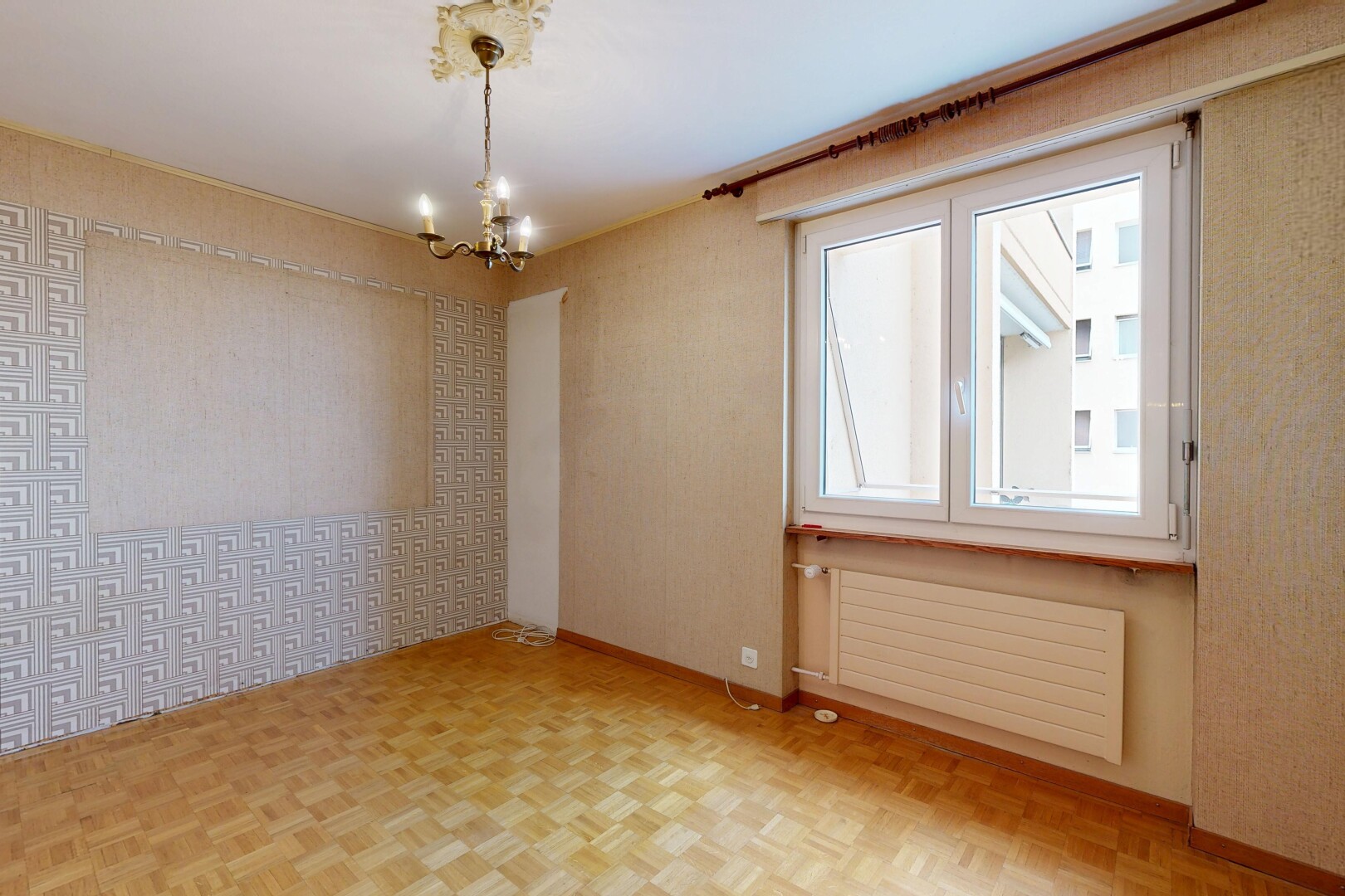 pièce vide avec radiateur, sol en finition bois, wood finish floor, inside property, et mur en papier peint