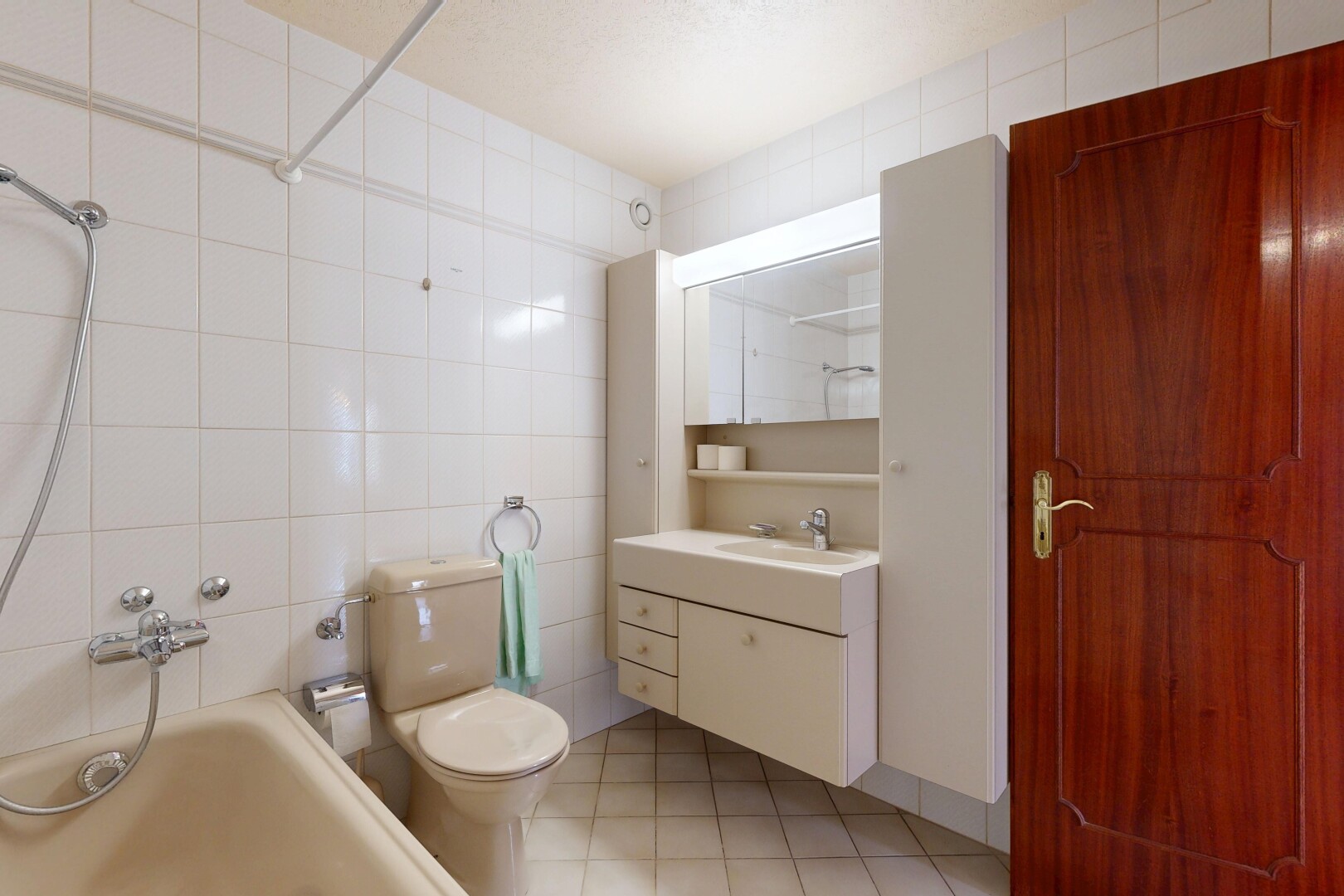 salle de bains avec tile wall, mur en carrelage, salle de bain complète, toilette, et miroir
