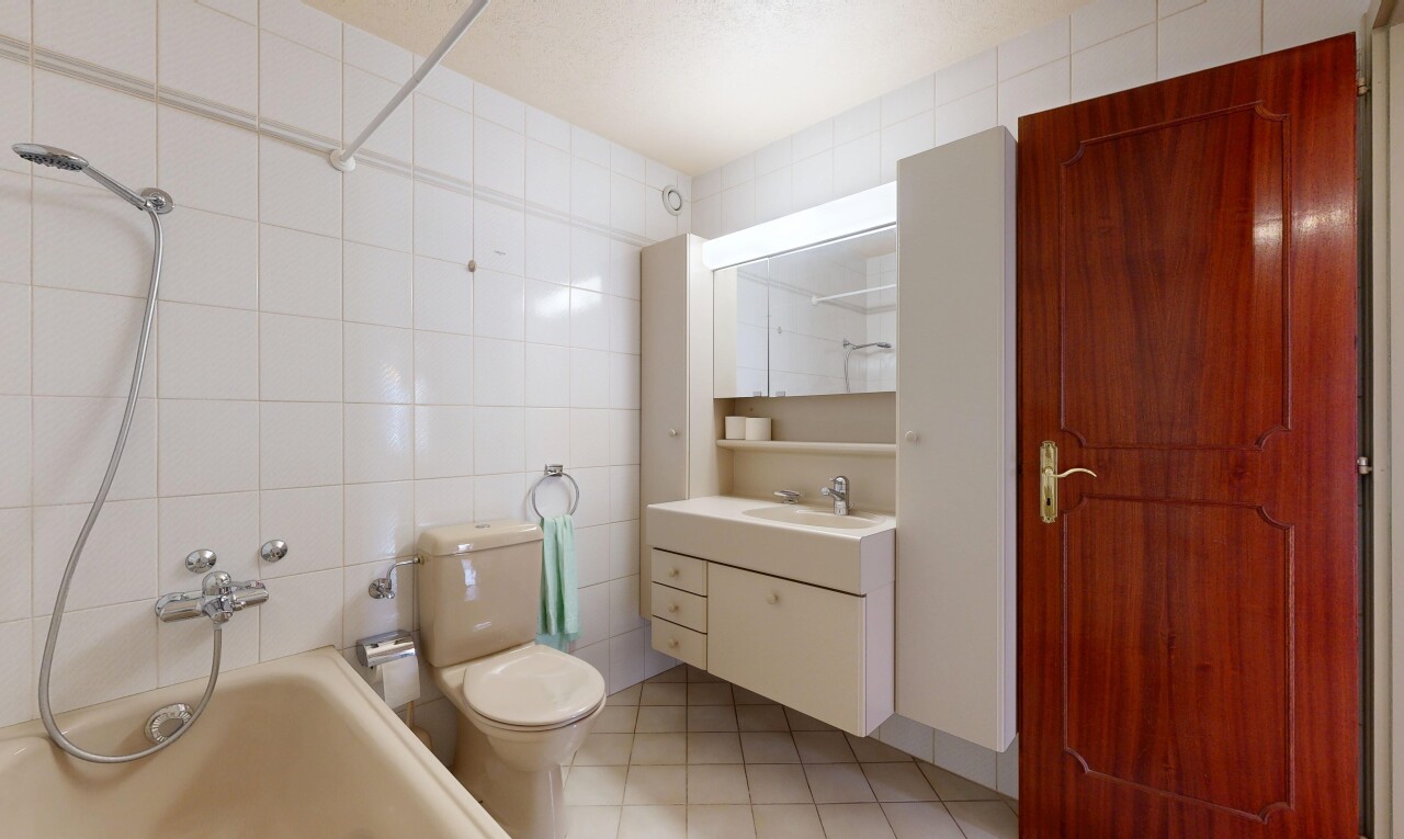 salle de bains avec tile wall, mur en carrelage, salle de bain complète, toilette, et miroir
