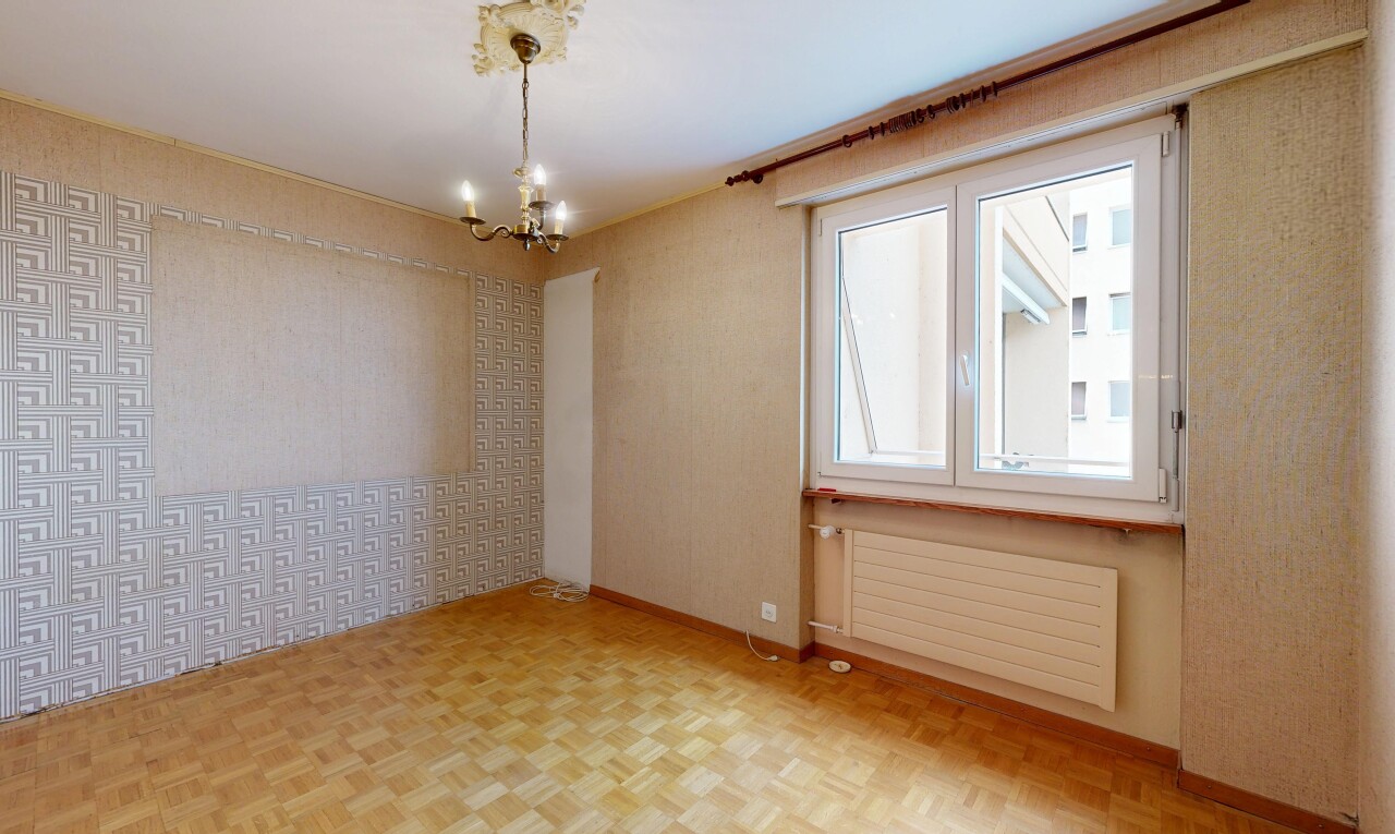 pièce vide avec radiateur, sol en finition bois, wood finish floor, inside property, et mur en papier peint