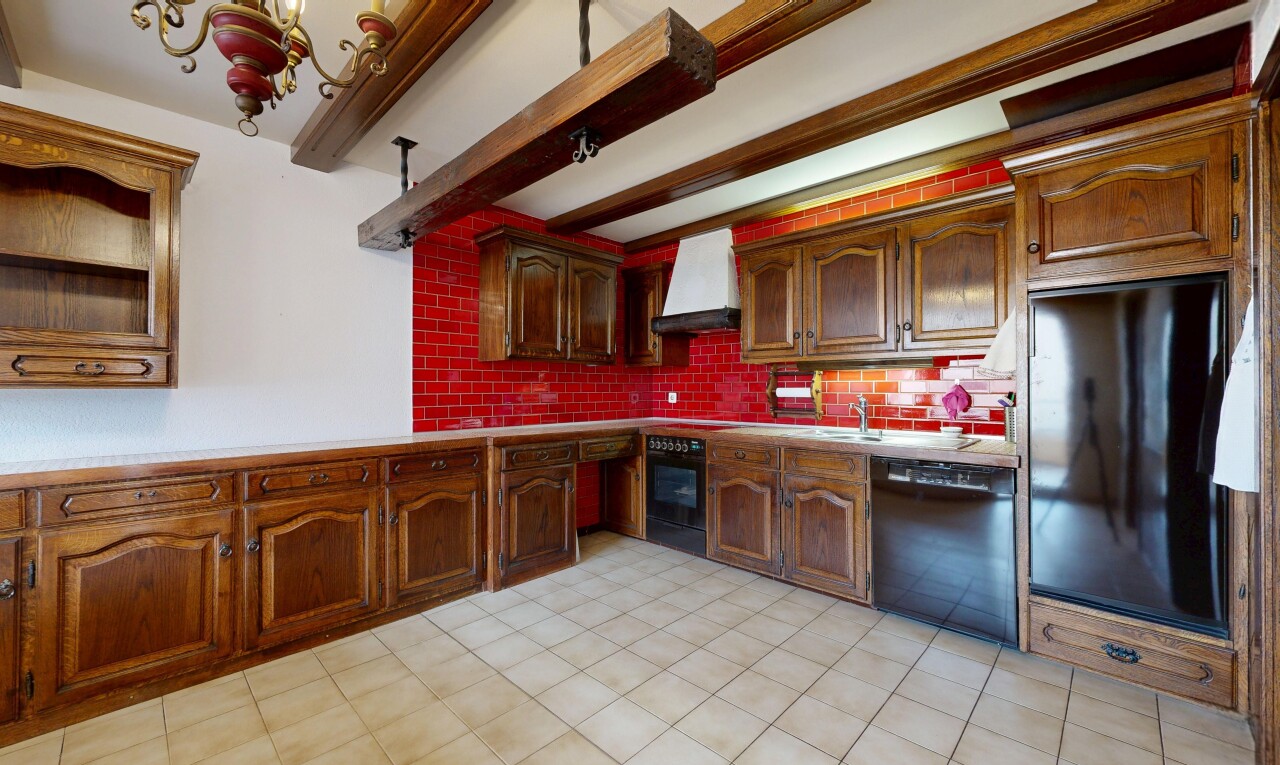 cuisine avec beamed ceiling, plafond à poutres, backsplash, dosseret, et arched cabinets