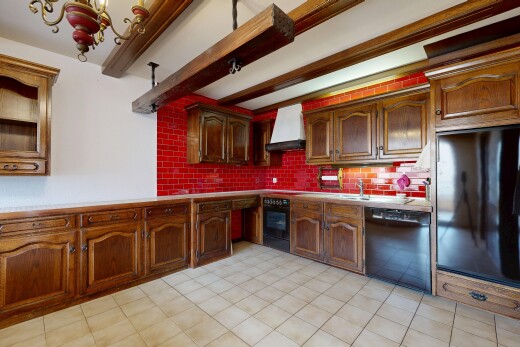 cuisine avec beamed ceiling, plafond à poutres, backsplash, dosseret, et arched cabinets