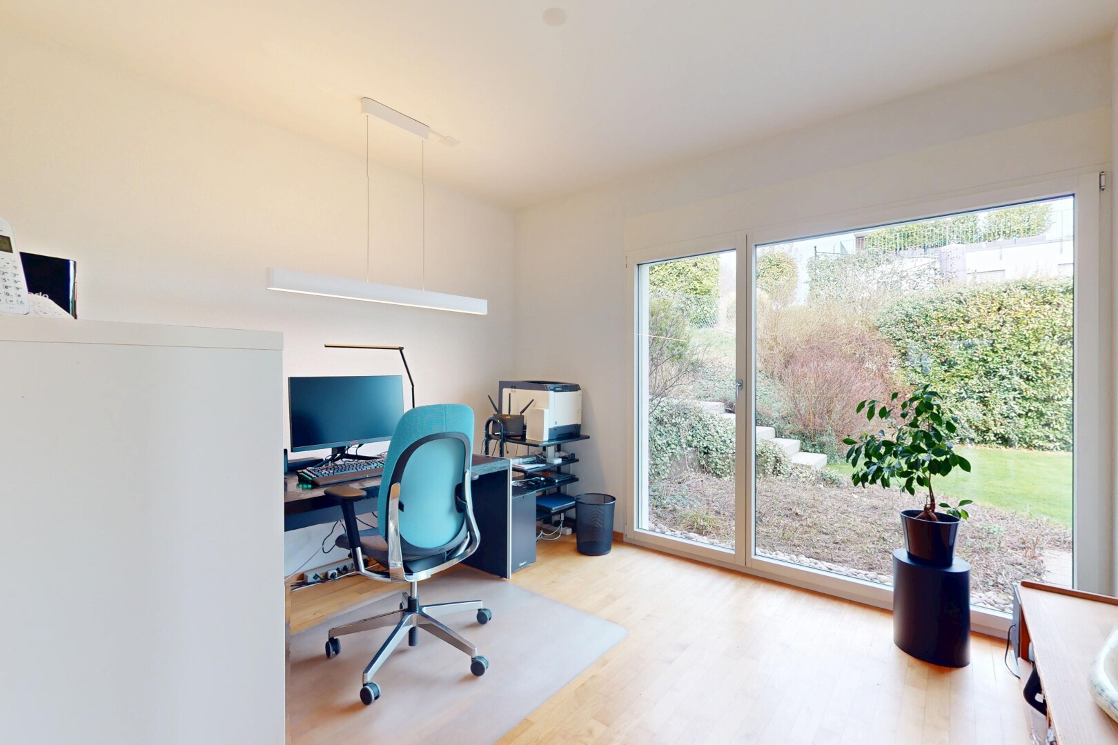 bureau avec télévision, espace bureau, lumière naturelle, cloison sèche, et sol en finition bois