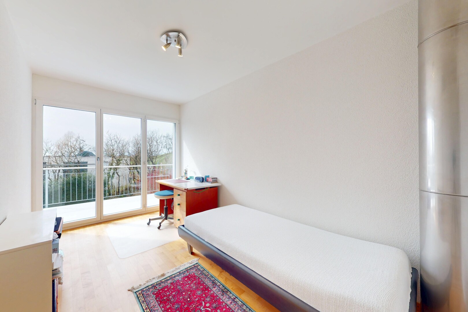 chambre avec lumière naturelle, cloison sèche, accès à l'extérieur, et sol en finition bois