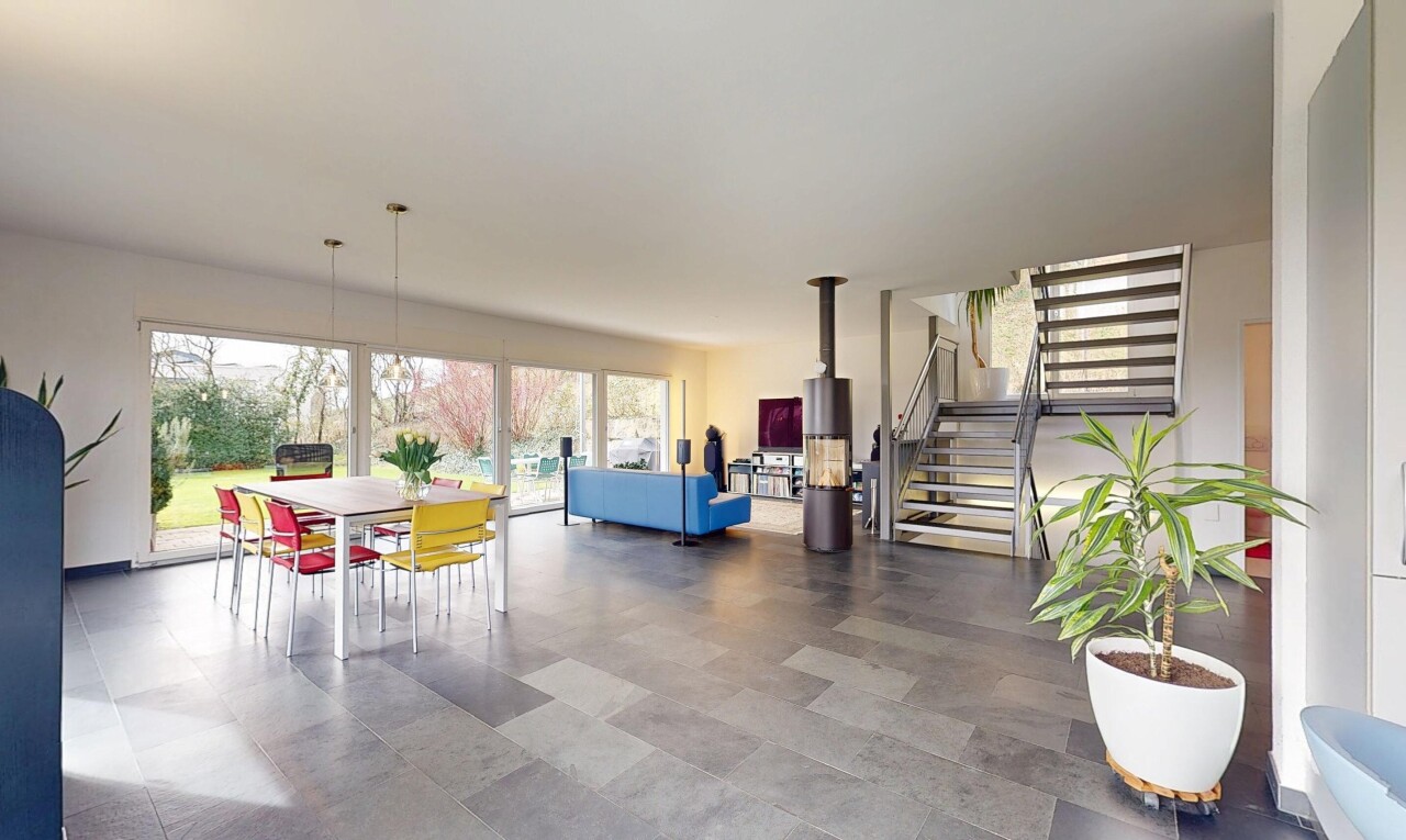 salon / salle à manger avec lumière naturelle, escaliers, et cloison sèche