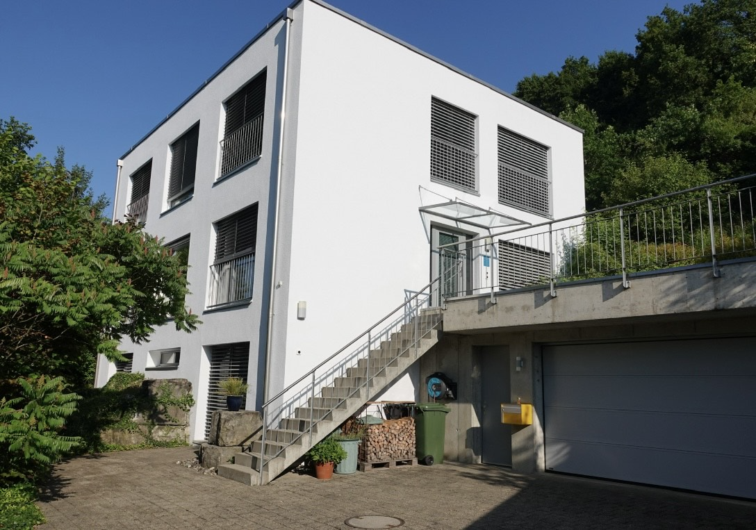 façade avec escaliers, bardage en stuc, property visible, et day time