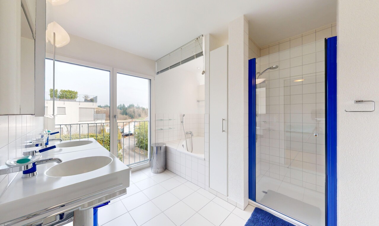 salle de bains avec douche, lumière naturelle, sol en carrelage, et bain