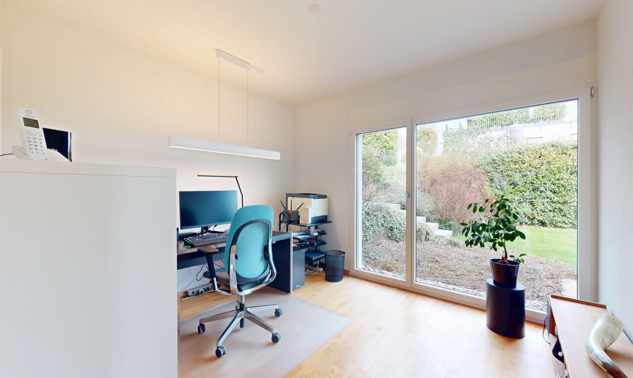bureau avec télévision, espace bureau, lumière naturelle, cloison sèche, et sol en finition bois