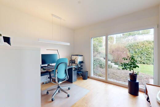 bureau avec télévision, espace bureau, lumière naturelle, cloison sèche, et sol en finition bois