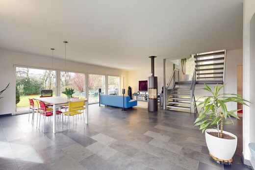 salon / salle à manger avec lumière naturelle, escaliers, et cloison sèche