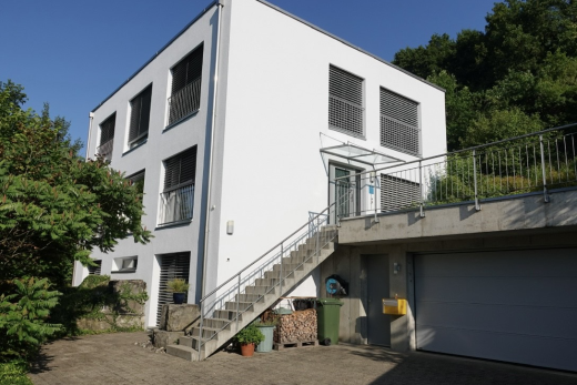 façade avec escaliers, bardage en stuc, property visible, et day time