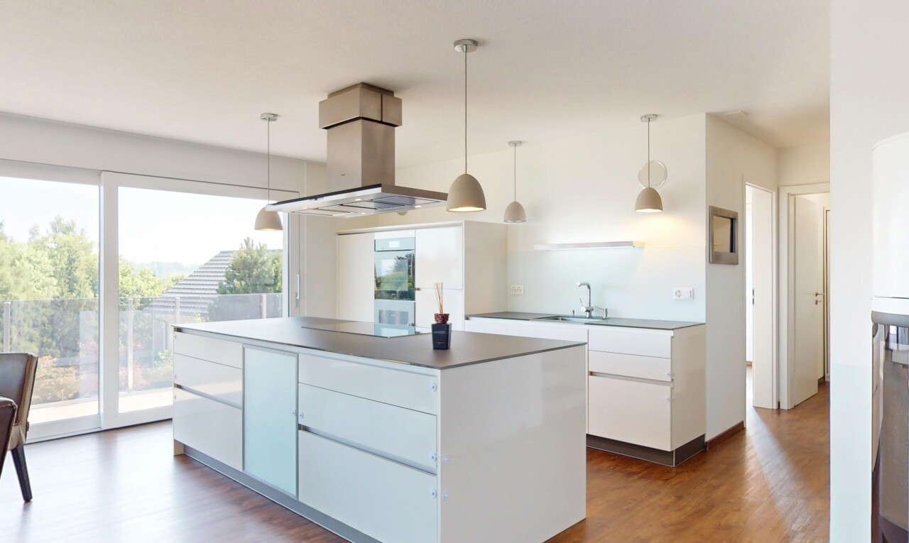 cuisine avec îlot de cuisine, lumière naturelle, natural light, sol en finition bois, et wood finish floor