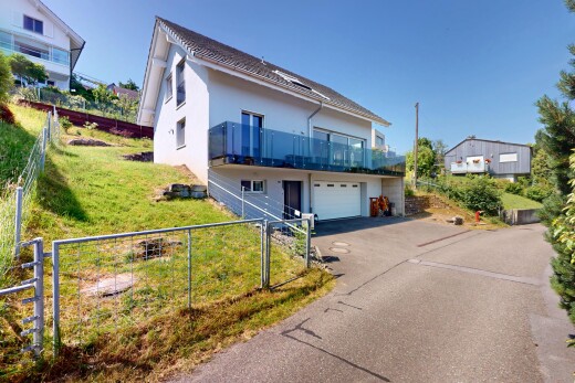 außenansicht mit balkon, auffahrt, property visible, eingebaute garage, und zaun
