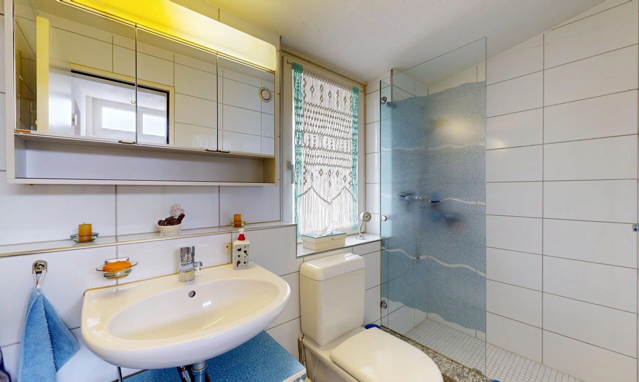 bathroom with walk in shower and tile walls