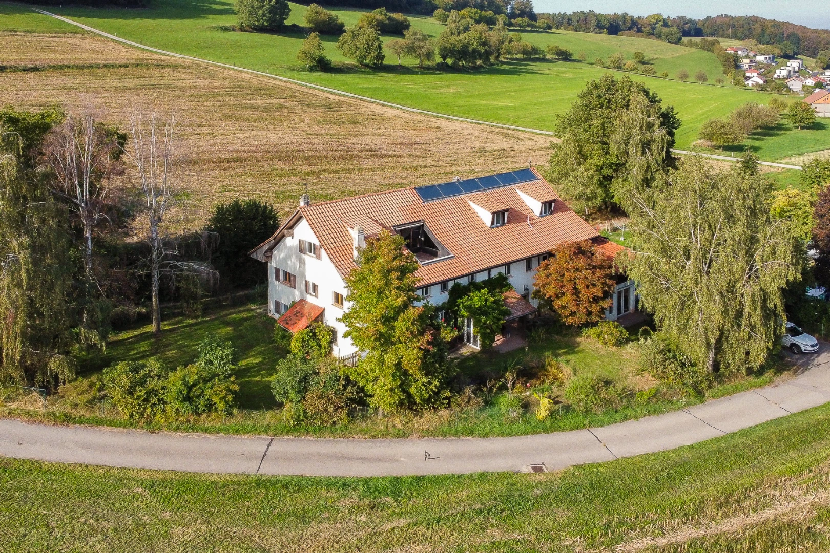 façade avec paneaux solaires, pelouse, et vue rurale