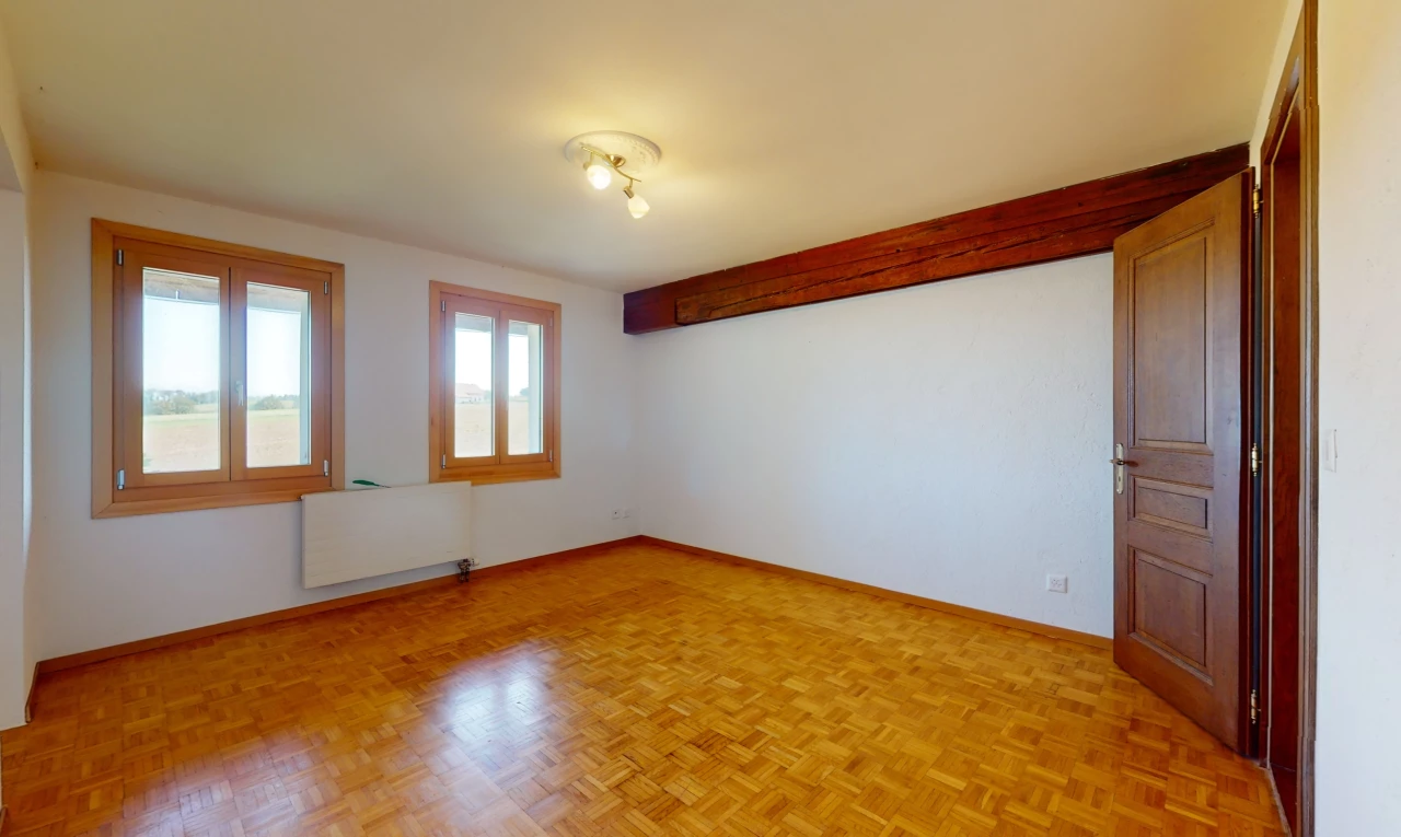 pièce vide avec radiateur, parquet, et lumière naturelle