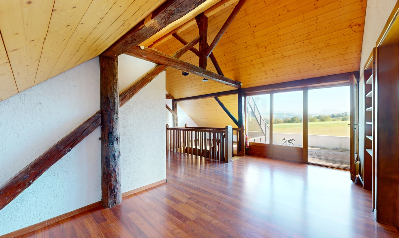 pièce vide avec plancher de bois, plafond voûté, plafond de bois, lumière naturelle, et poutres apparentes