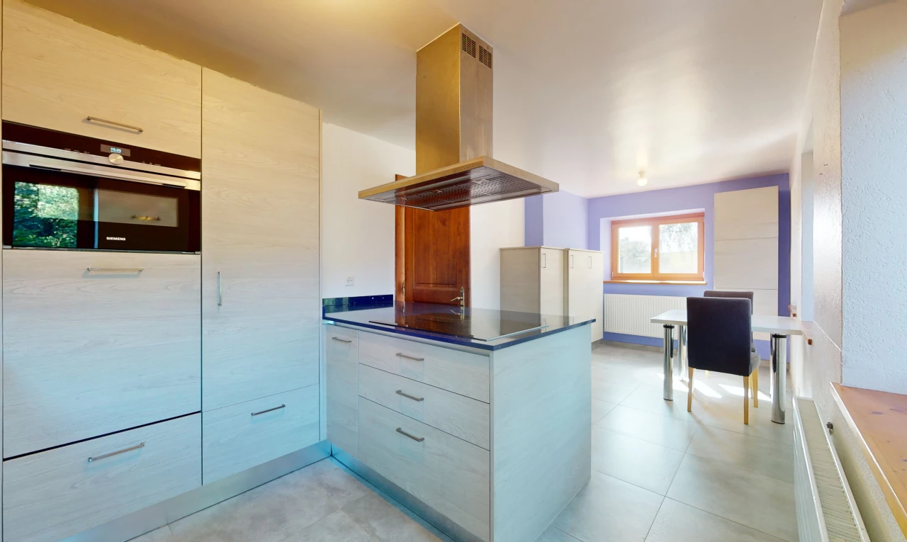 cuisine avec lumière naturelle, hotte, four, carrelage, et meubles à panneaux plats