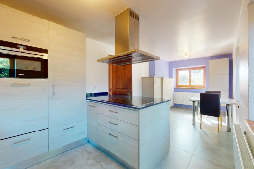 cuisine avec lumière naturelle, hotte, four, carrelage, et meubles à panneaux plats