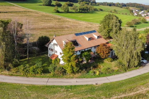 façade avec paneaux solaires, pelouse, et vue rurale