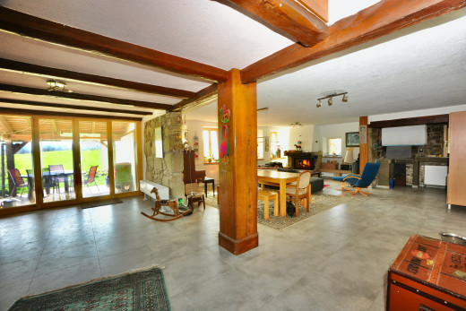 espace intérieur avec poutres apparentes, lumière naturelle, et carrelage