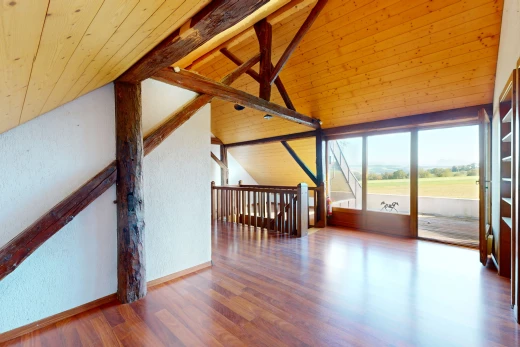 pièce vide avec plancher de bois, plafond voûté, plafond de bois, lumière naturelle, et poutres apparentes