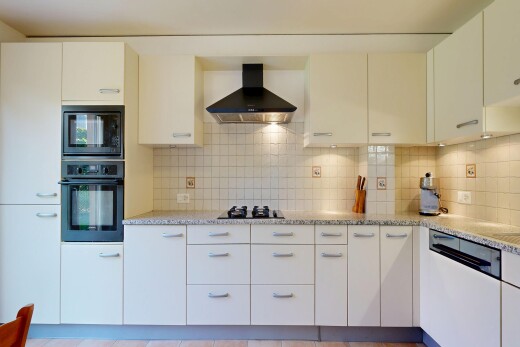 cuisine avec light countertops, four, hotte, white cabinets, et armoires blanches