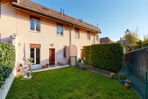 façade avec clôture, pelouse, property visible, bardage en stuc, et toit en tuiles
