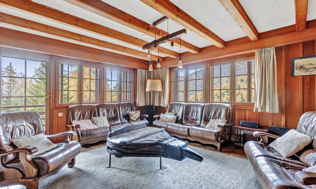 living room with beamed ceiling, wooden walls, and a textured ceiling