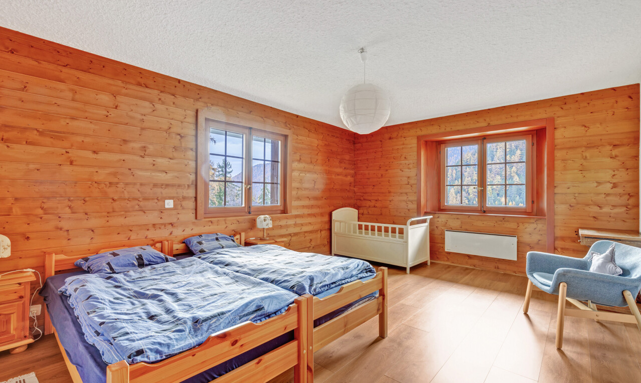 room / bedroom featuring wooden walls, multiple windows, and a textured ceiling