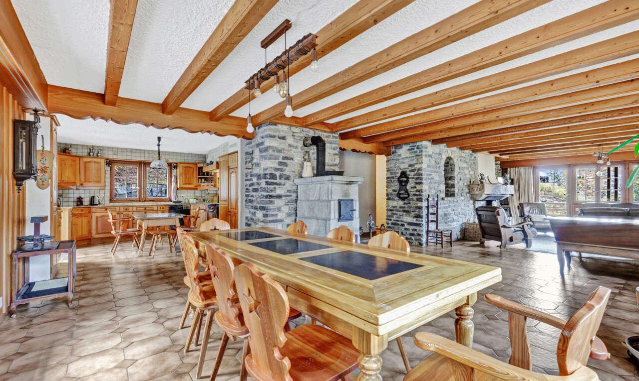 dining area with beam ceiling and a wood stove
