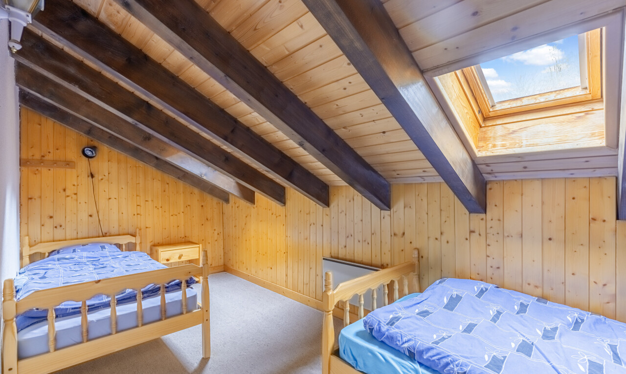 zimmer / schlafzimmer mit inside property, zusätzliches zimmer, holzwand, wood wall, und balkendecke